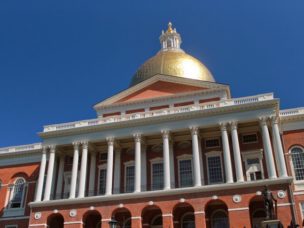 The state house brick building with gold dome on top of it.