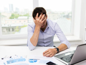 businessman with laptop and papers in office