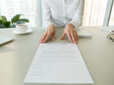 Female hr or employer offering employment agreement document for reading labor contract terms and work conditions, hiring new employee process and getting job, recruitment concept, close up view