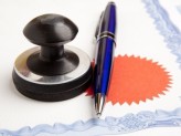 a stamp and a blue pen on top of a certificate