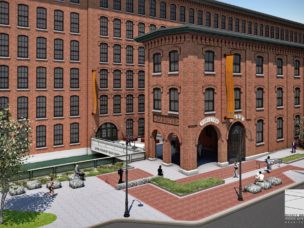 brick building with many windows and sidewalk and trees out front