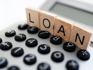 calculator with the word loan written in wooden block letters