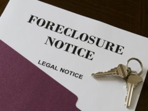 a paper with the words "real estate home foreclosure legal notice" and keys on top of the paper