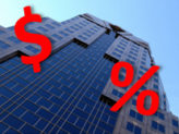 skyscraper building with blue sky and a red money sign and red percent sign