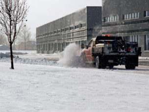truck plowing parking lot of office building