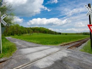 country railroad crossing: a narrow gravel road crosses a set of railroad tracks in rural virginia.