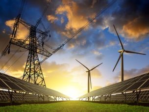 green grass, solar panels, wind mills, a Electric power transmission and a sunset in the background