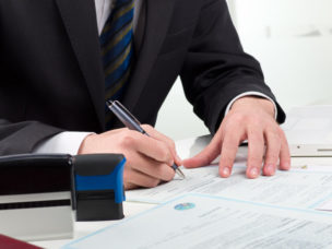 Man in a suit notarizing a document