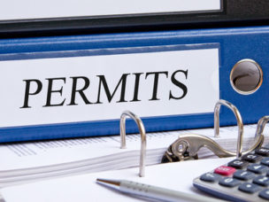 the word "permits" labeled on a blue binder in a office