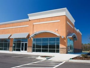 orange building with a parking lot and a blue sky in the background