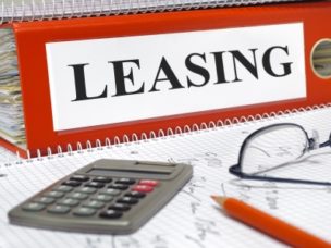 "leasing" labeled on red binder in a office workspace