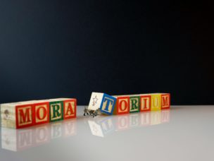 letter blocks reading "moratorium" o na white table with black background