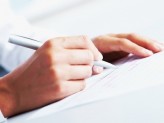 hands writing on a paper with a pen