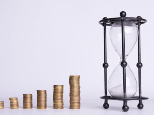 stacks of money and hourglass on a white background