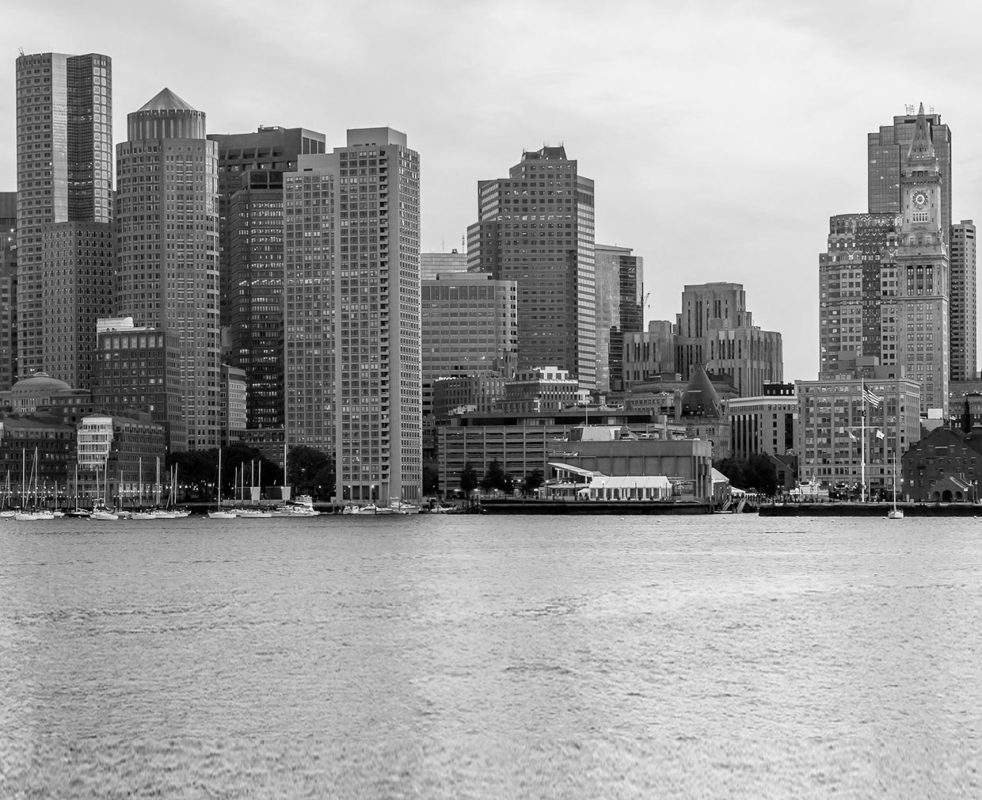 Black and white picture of Downtown Boston with skyscrapers over Boston Harbor