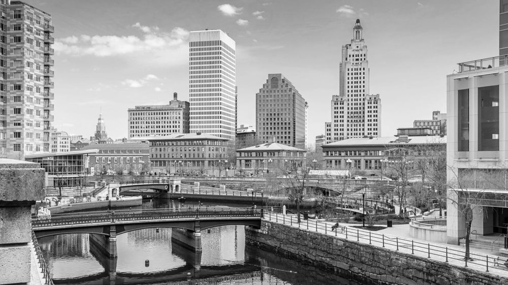 Black and white photo of dowtown Providence with skyscrapers overlooking bridge