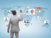 businessman looking at map of other businessmen and women across the world